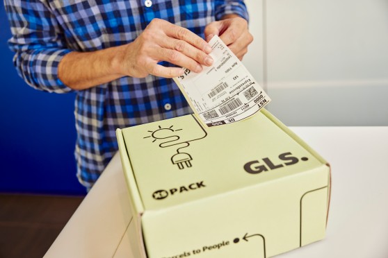 Ein Paketlabel wird auf das Paket geklebt