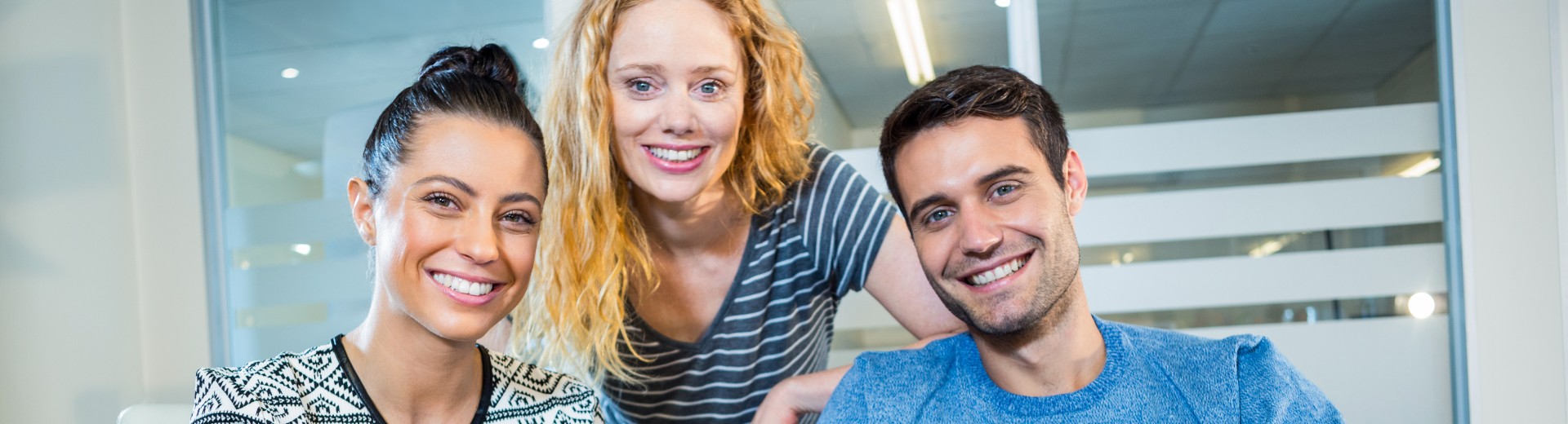 Drei Angestellte schauen auf ein Tablet