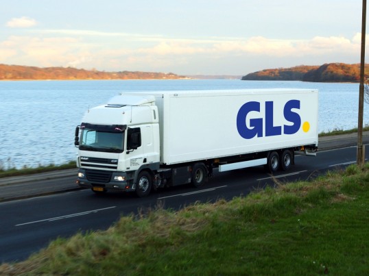GLS-vrachtwagen rijdt langs het water
