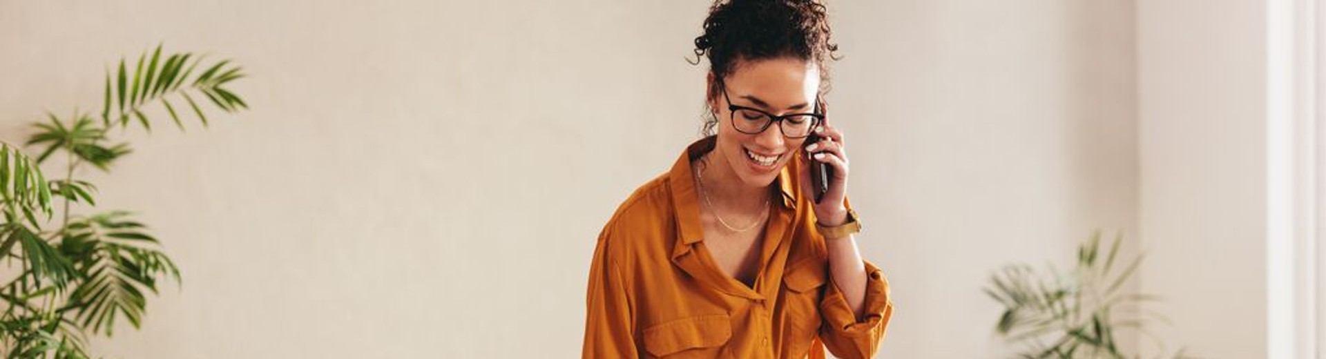 Vrouw die aan de telefoon praat met GLS-pakketten naast haar