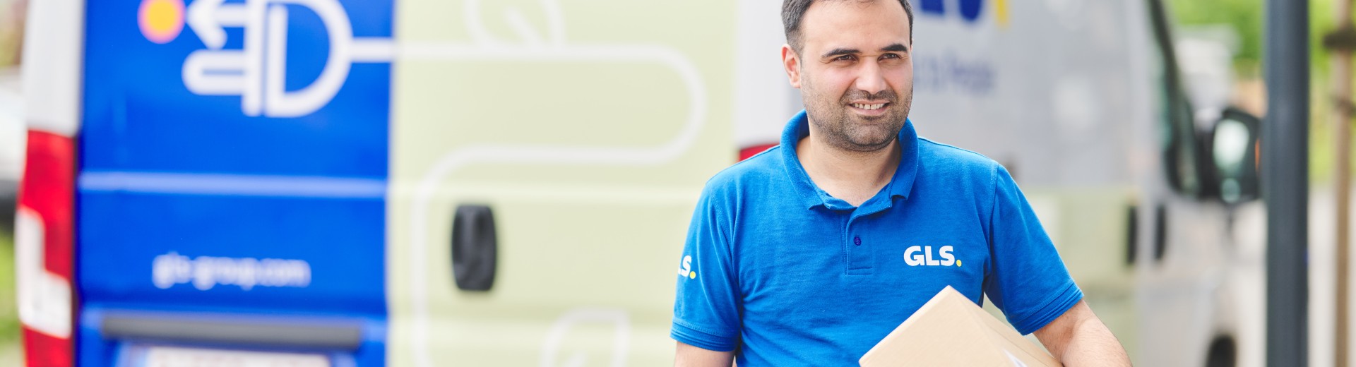 Bezorger die een pakket vasthoudt voor zijn e-van