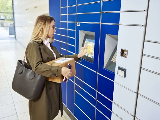 Een vrouw staat bij een GLS Parcel Locker