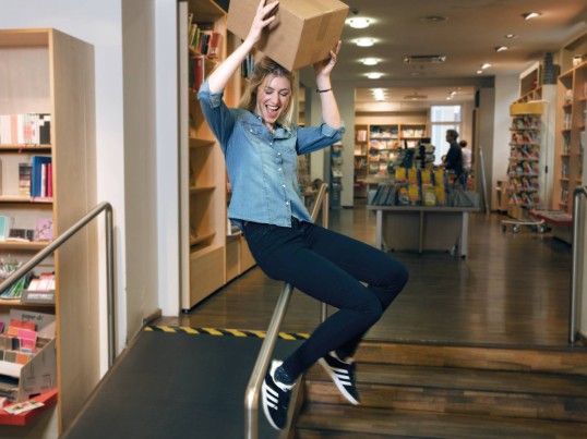 Een man springt de lucht in terwijl hij een pakket vasthoudt