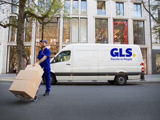 Un mensajjero de GLS reparte un paquete.