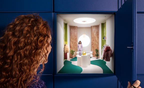 Nainen avaa pakettiautomaatin lokeron, jonka sisältä avautuu näkymä myymälään ja verkkokauppiaan GLS-noutopisteisiin.