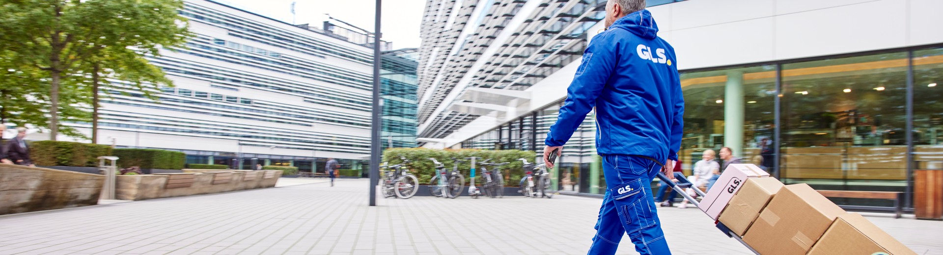 GLS-työntekijä kuljettaa paketteja kaupungilla 
