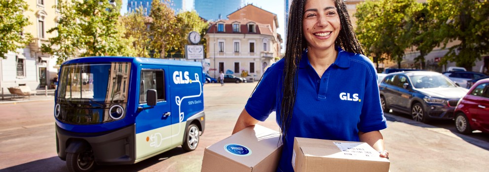 Hymyilevä GLS-työntekijä kävelee kameraa kohti