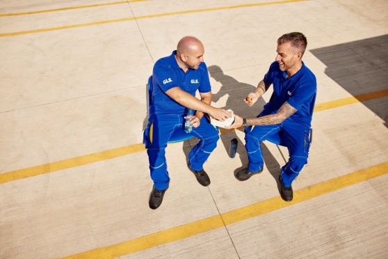 Deux collaborateurs GLS en pause sur site logistique, échangeant dans un environnement de travail extérieur, illustrant les actions liées à la qualité de vie et aux conditions de travail (QVCT).