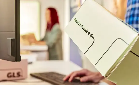 Gros plan sur un client remettant un colis GLS à un comptoir d’expédition, illustrant une solution d’envoi dédiée aux professionnels.