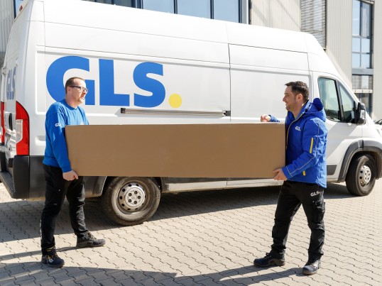 Két GLS futár viszi az XXL csomagot.