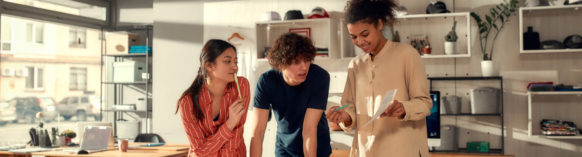 Drei Personen schauen auf ein Stück Papier