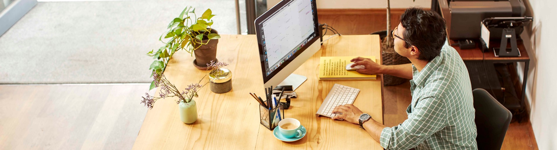 Mann, der in einem Laden am PC arbeitet