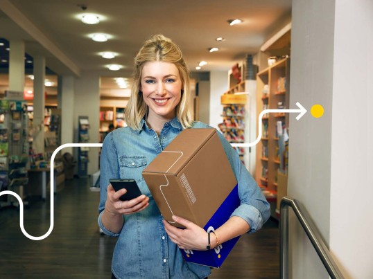 Eine lächelnde Frau hält ein Paket