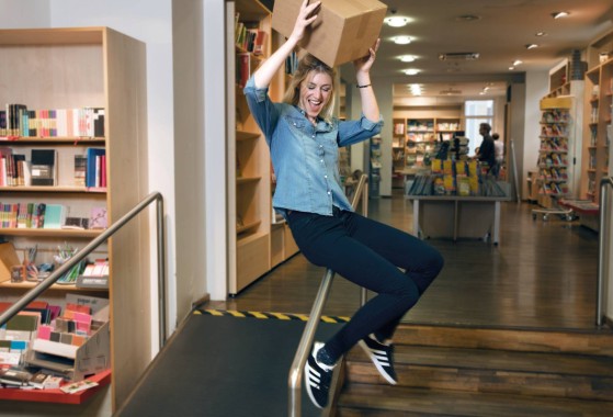 Eine lächelnde Frau springt, während sie ein Paket hält