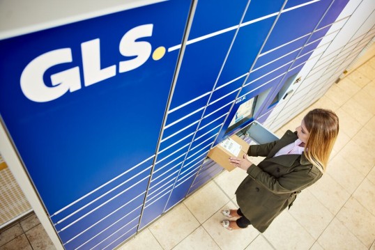 Vrouw die voor een GLS Parcel Locker staat