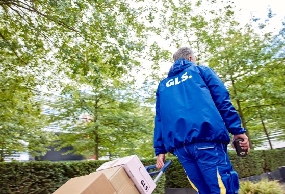 Distrubuidor da GLS Portugal a transportar várias encomendas numa área urbana