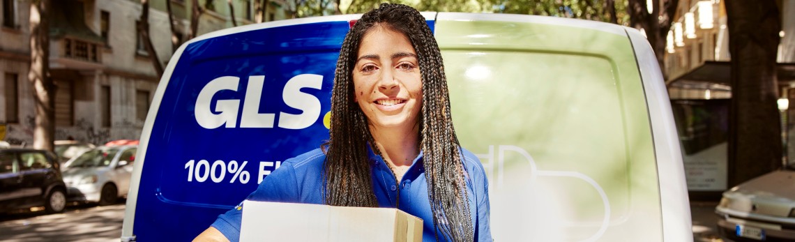 femeie curier in fata mașinii de livrare GLS