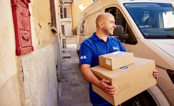 curier GLS în fața mașinii de livrare