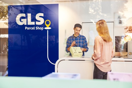 Femeie care ridică o trimitere de la GLS Parcel Shop