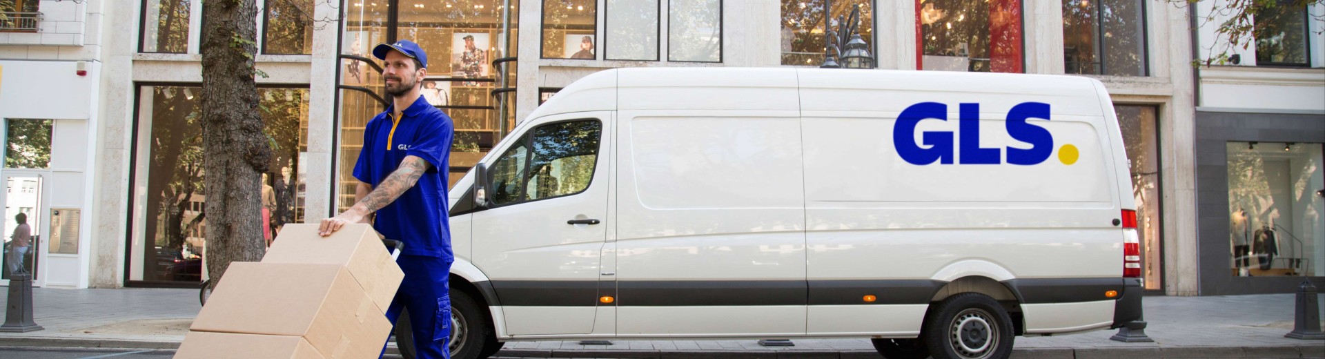 Kurir GLS raznaša pakete z vozilom GLS v ozadju