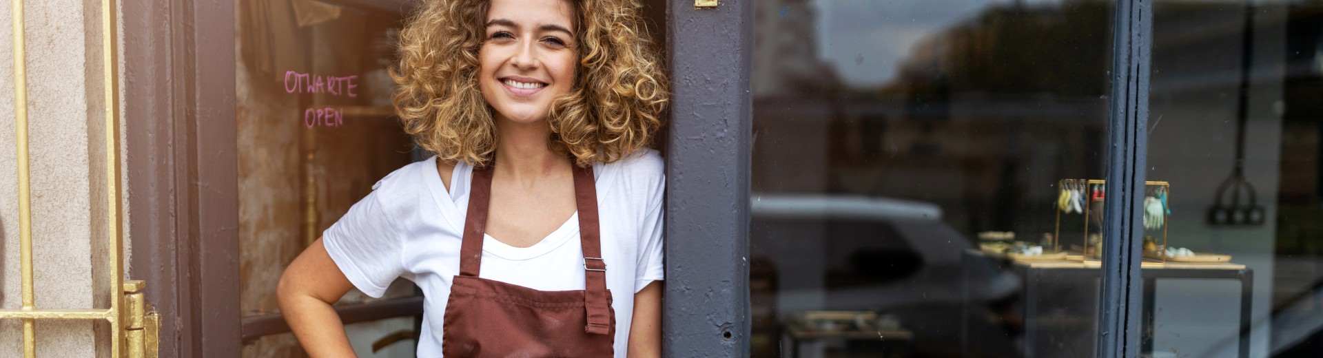 Ženska stoji pred svojo trgovino