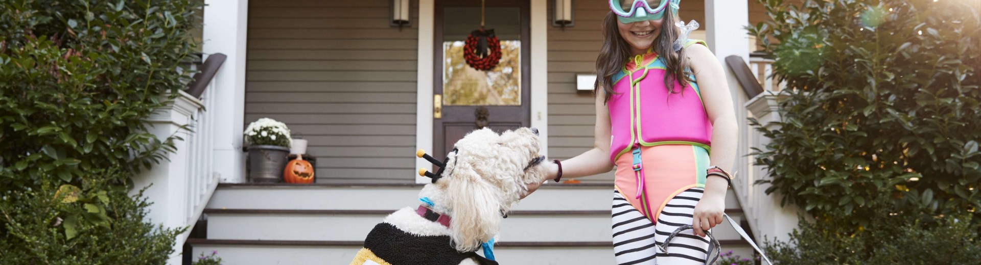 Punčka se igra s psom pred hišo