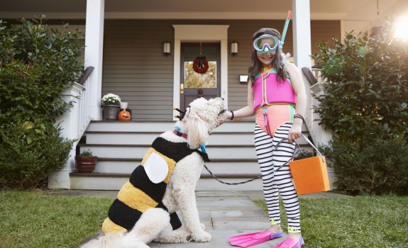 Punčka se igra s psom pred hišo