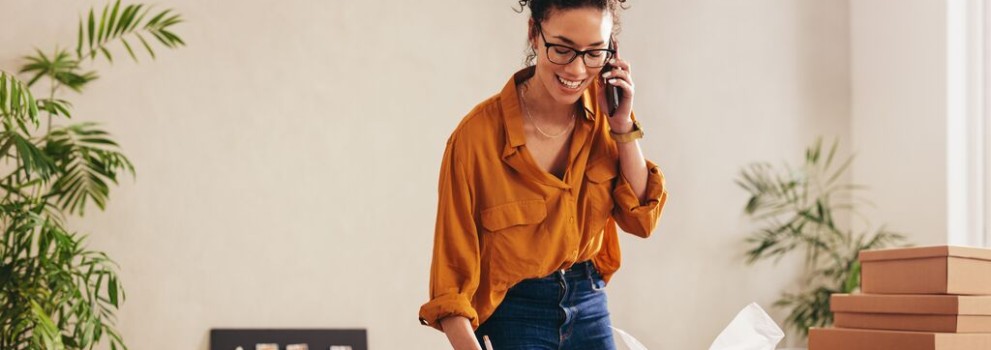 Ženska se pogovarja po telefonu in drži dokumente